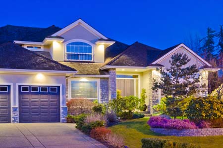 Large single family home at night with outside lights - Homeowners Insurance